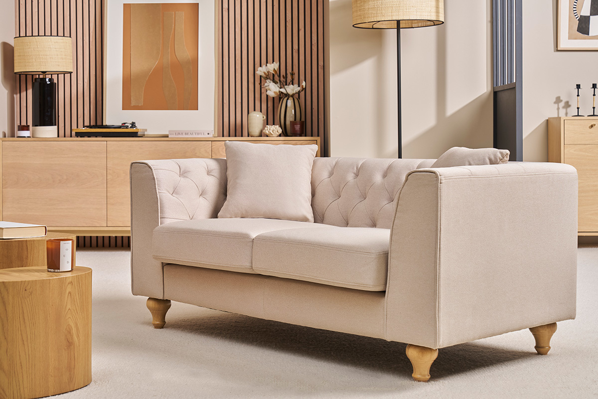 Canap� beige 2 places MONTAIGNE avec accoudoirs et dossier capitonn�, vue de face.