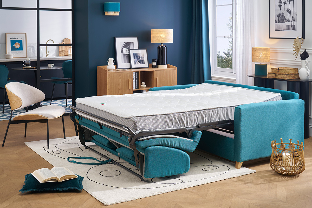 Canap� convertible bleu canard avec matelas d�pli� dans un salon moderne.
