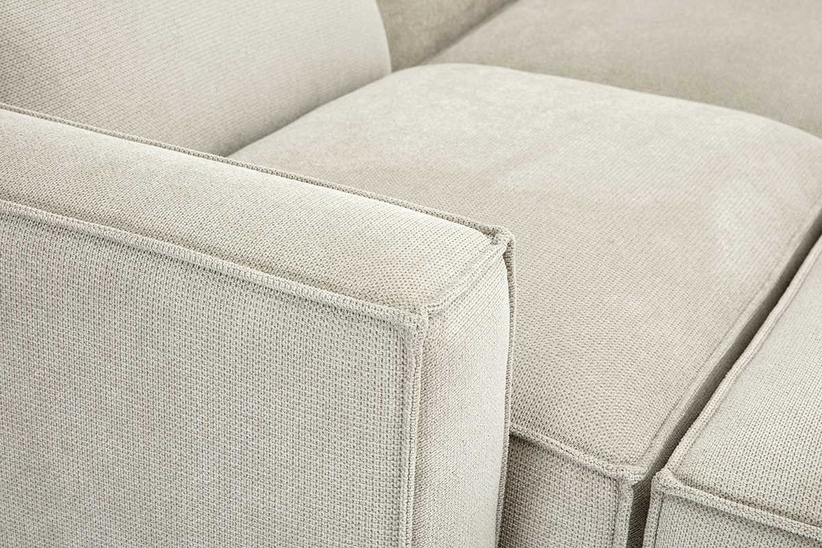 Gros plan sur un canap� d'angle modulable en tissu effet velours textur� beige.