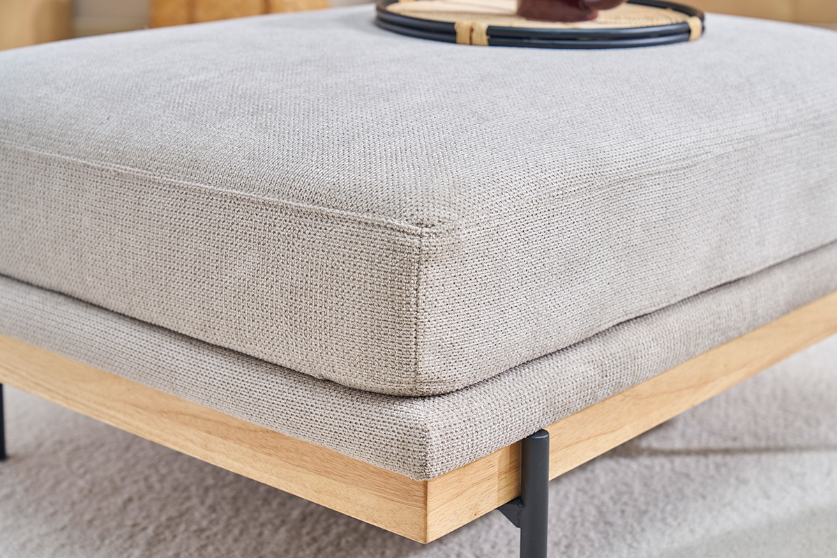 Gros plan sur le repose-pieds en tissu chenille beige du canap� TODD, structure en m�tal noir et bois visible.