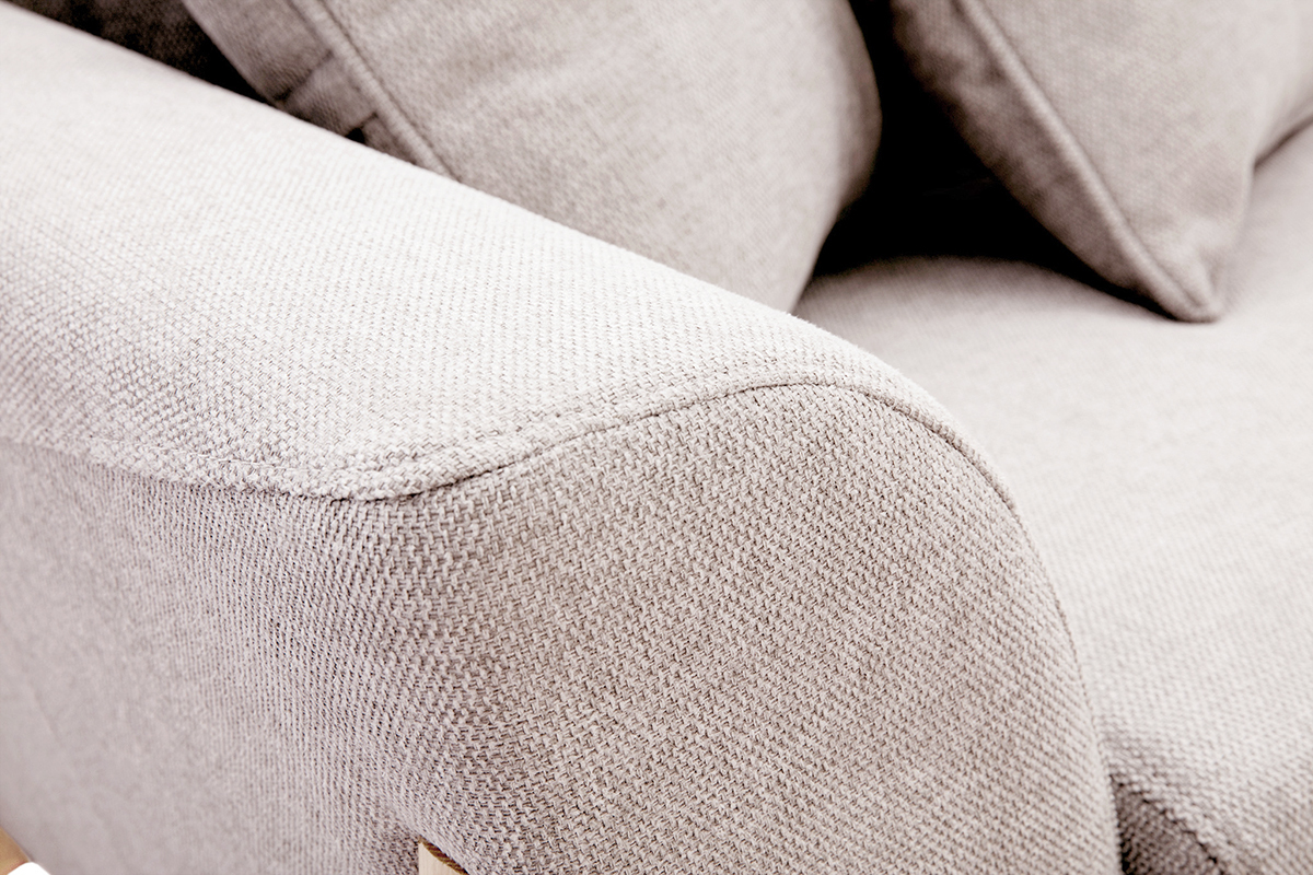 Gros plan sur un accoudoir d'un canap� en tissu effet velours textur� beige.