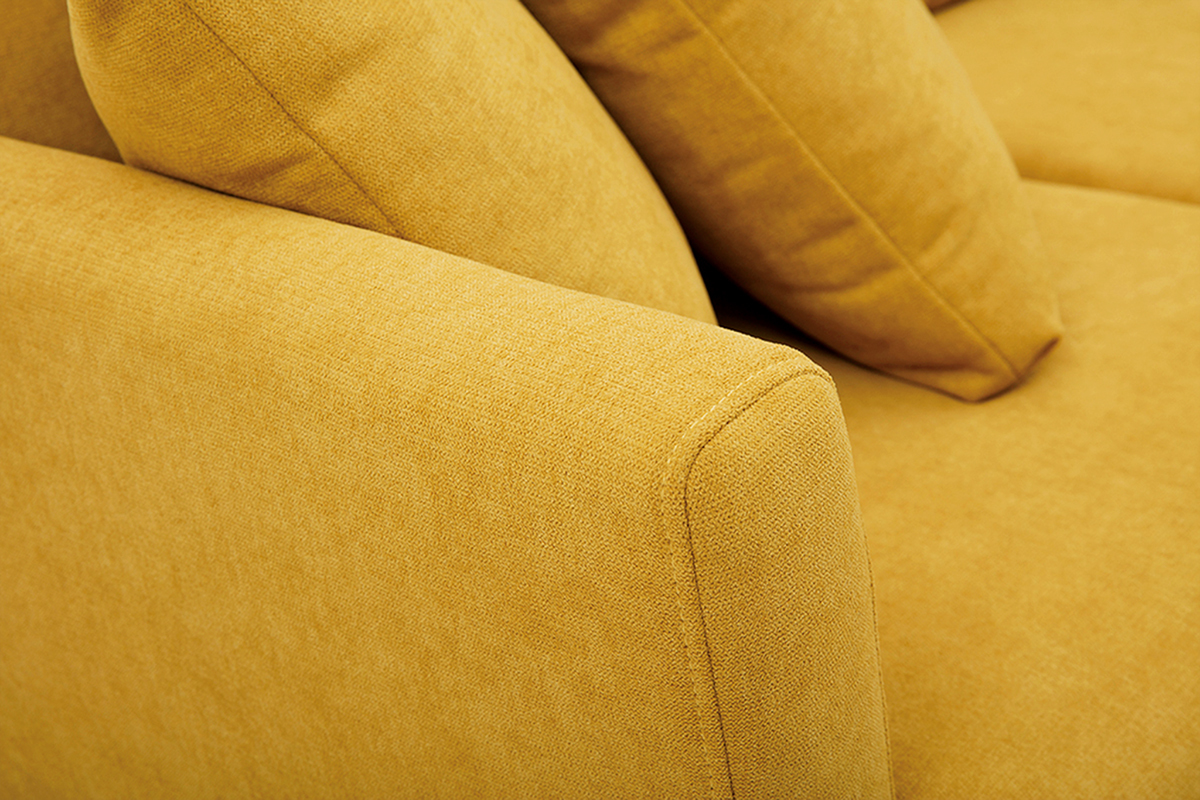 Plan serr� sur un canap� en tissu effet velours jaune moutarde avec coussins.