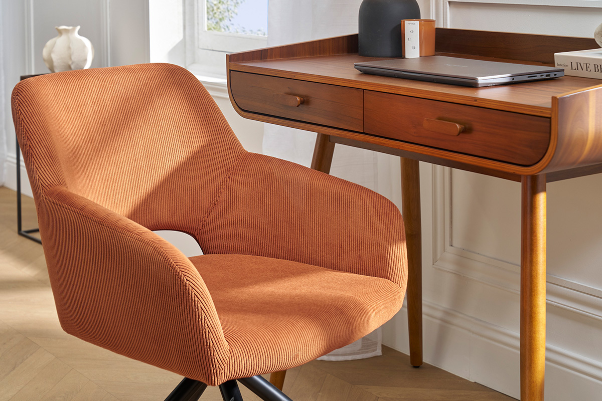 Chaise pivotante en velours c�tel� terre br�l�e � c�t� d'un bureau en bois, vue d'int�rieur.