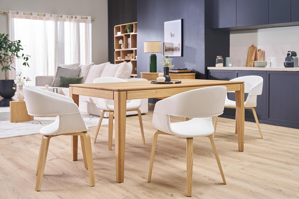 Salle � manger avec chaises SLAM blanches et pieds en bois clair autour d'une table en bois.