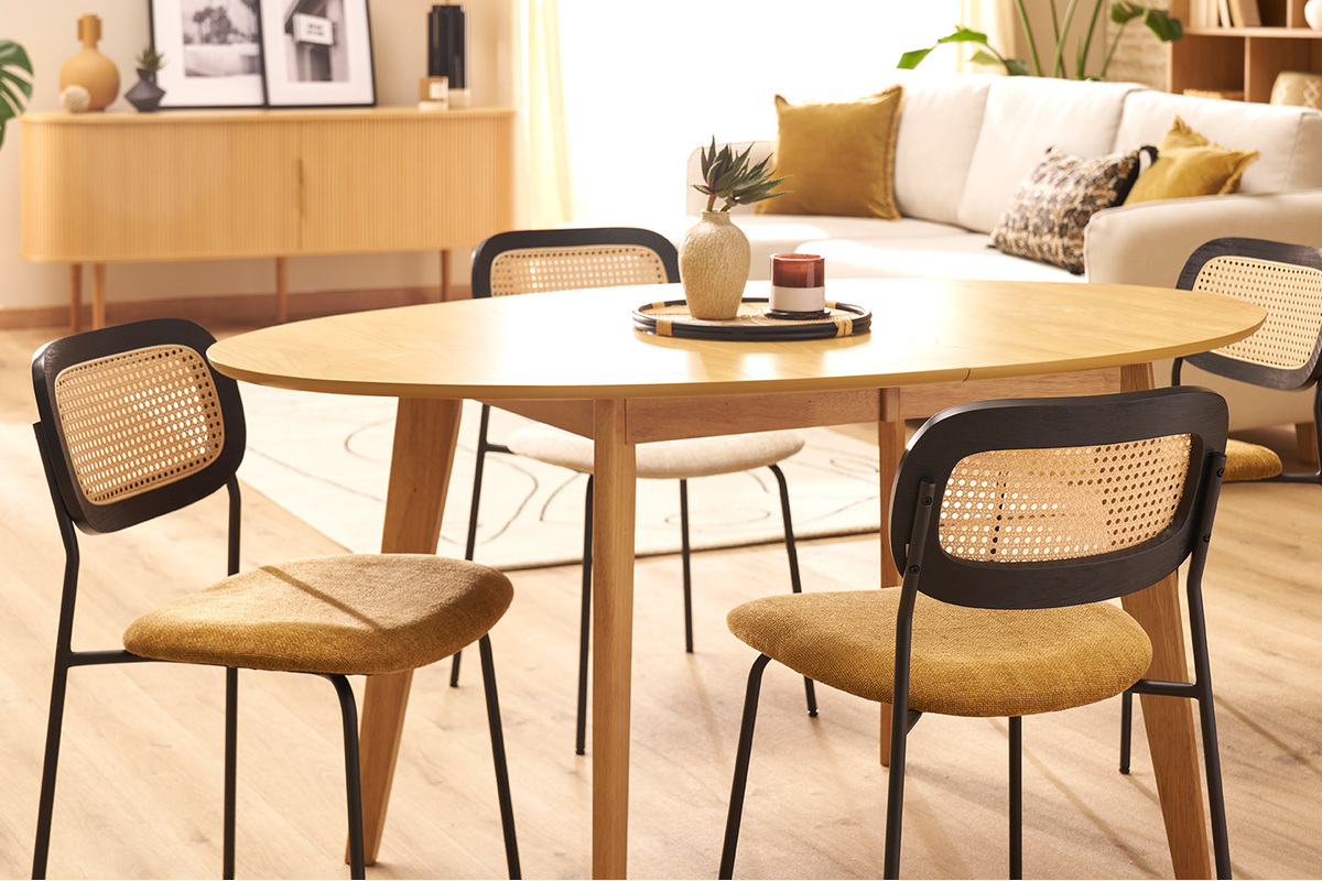 Chaises en tissu bronze et cannage rotin autour d'une table en bois dans un salon.
