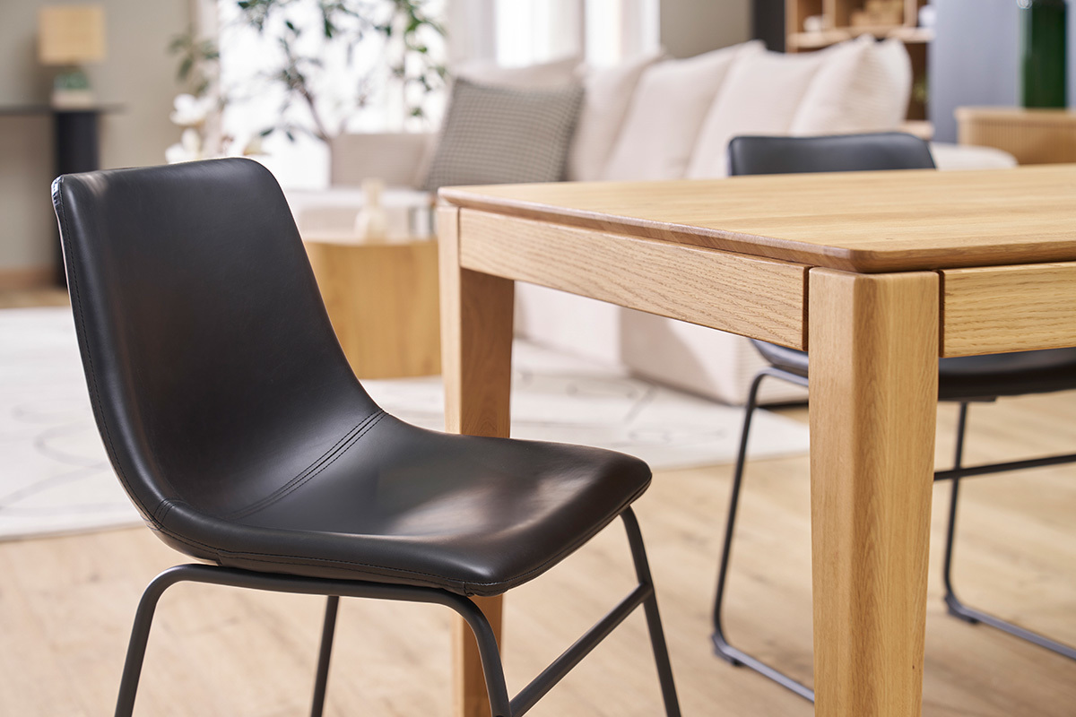 Chaise noire industrielle NEW ROCK devant une table en bois dans un int�rieur moderne.