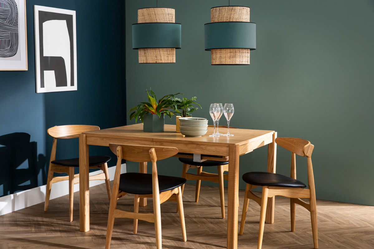 Chaises scandinaves en bois clair et noir autour d'une table, vue d'int�rieur.