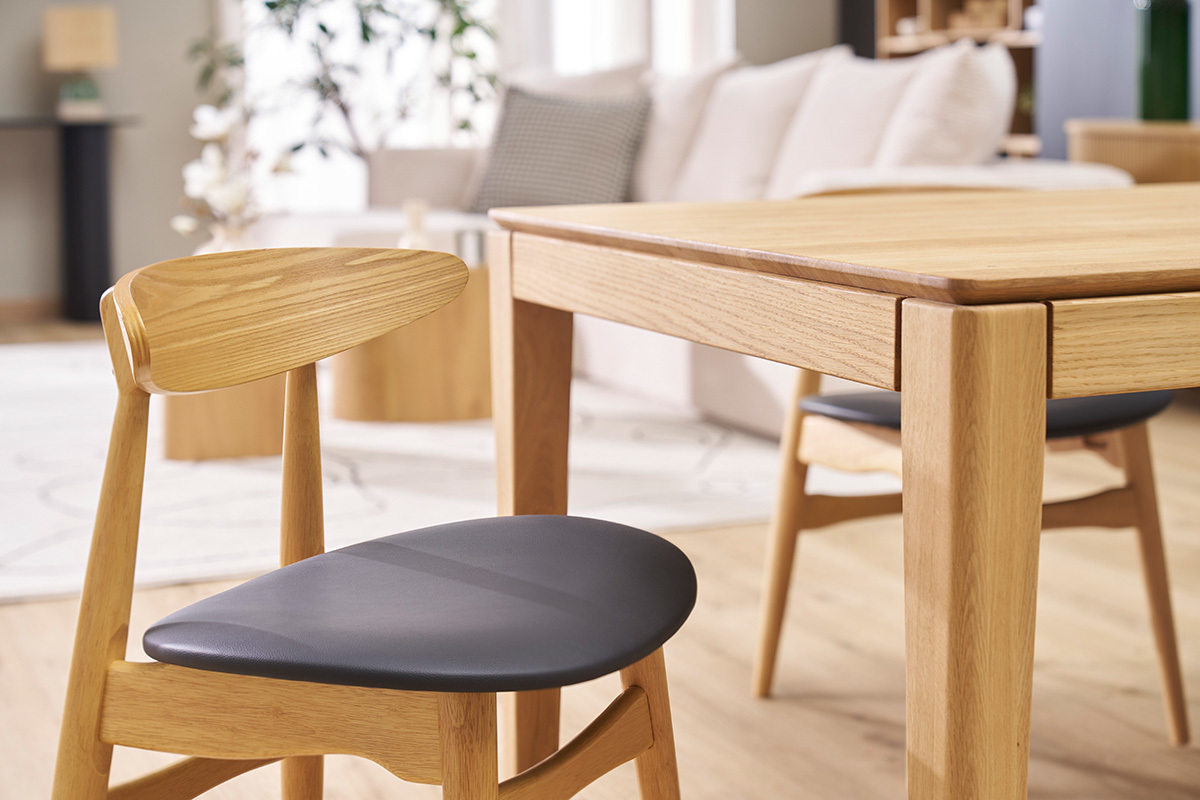 Chaises WALFORD en bois clair et noir autour d'une table en bois clair, vue de c�t�.