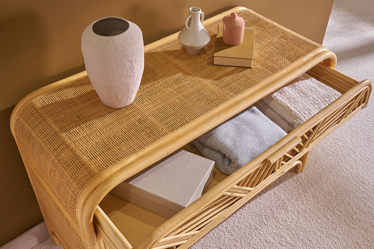 Commode vintage en rotin avec tiroir ouvert et objets d�coratifs sur le dessus.