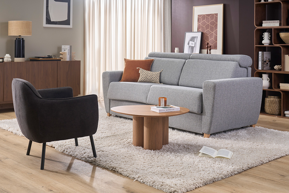 Fauteuil design en tissu effet velours gris fonc�, vue de c�t�, avec des meubles modernes autour.