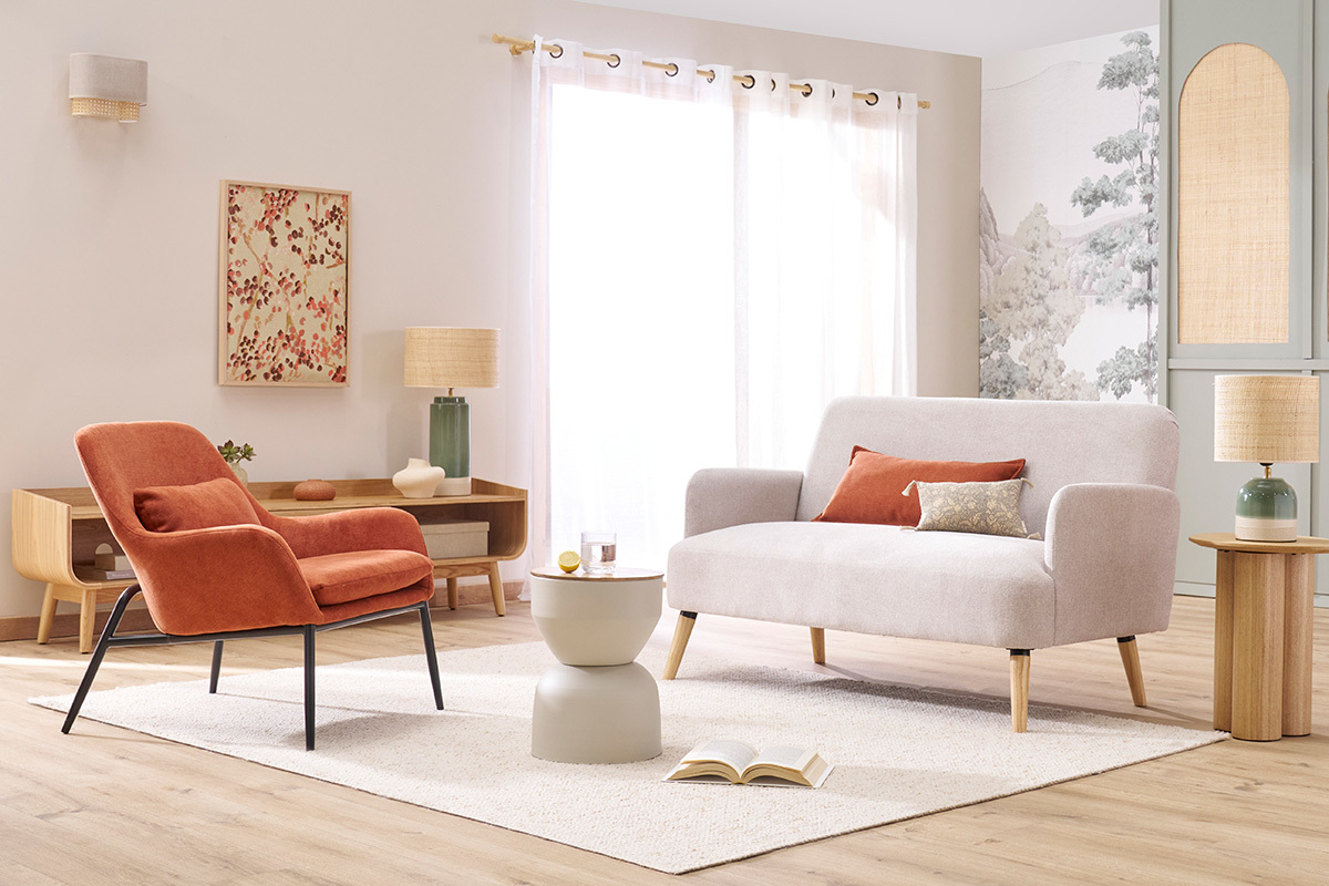 Fauteuil design en tissu terre brul�e avec pieds en m�tal noir, vue de face dans un salon moderne.