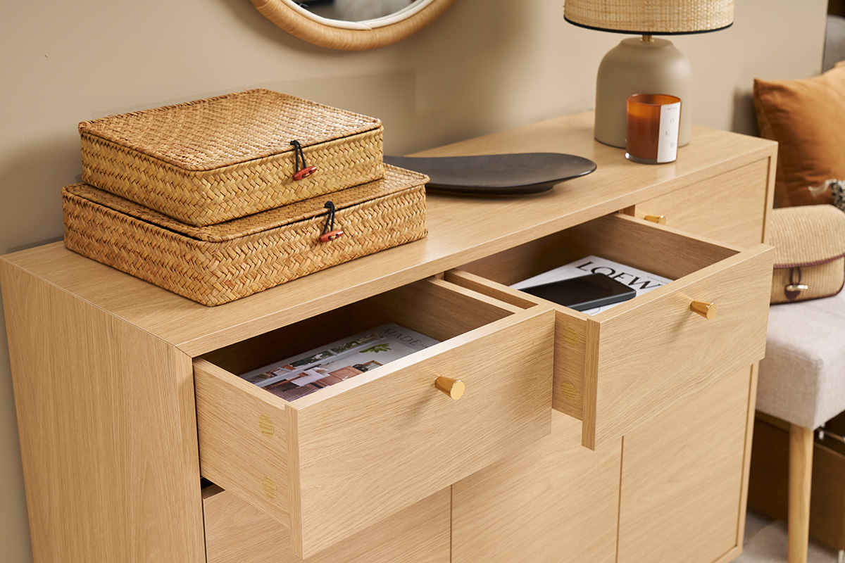 Meuble d'entr�e en bois clair avec tiroirs ouverts et objets dessus, vue de 3/4.
