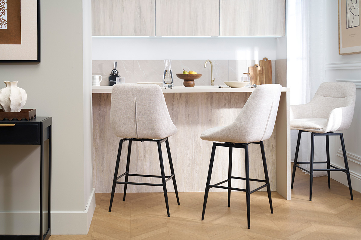 Tabourets de bar beige effet velours et m�tal devant un comptoir.