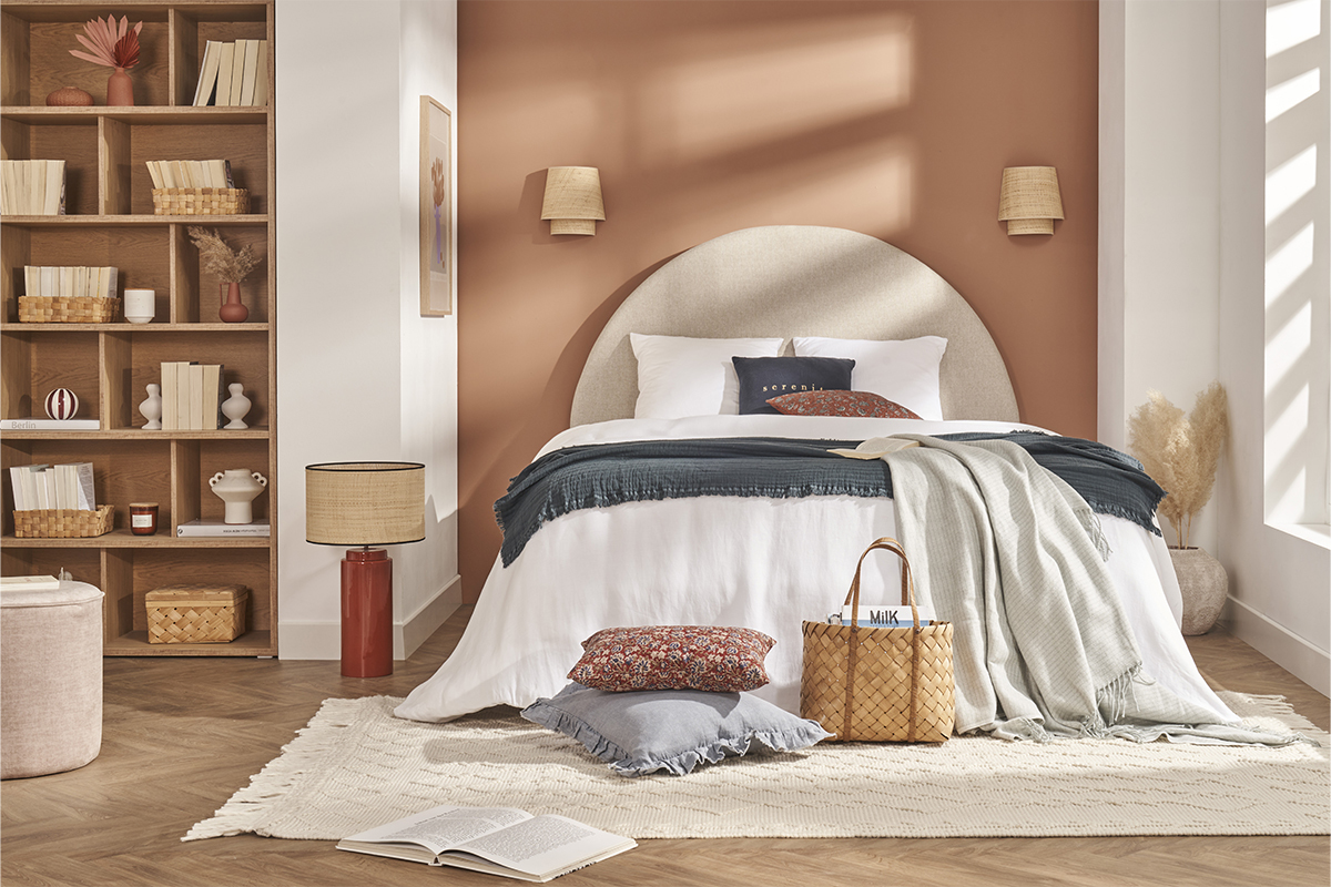T�te de lit ronde en tissu beige, chambre avec d�co et accessoires.